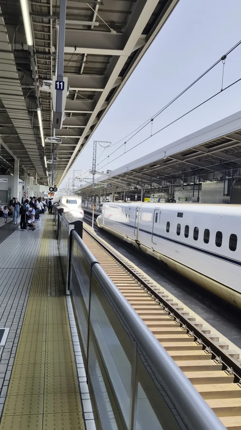 Shinkansen bullet train arriving at Shin-Osaka Station platform, Japan.