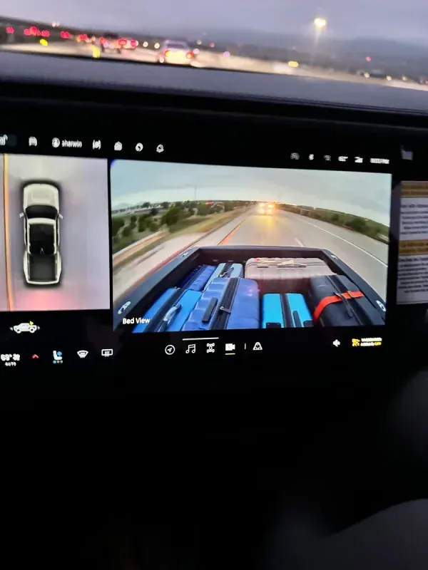Truck bed camera view with luggage on highway at dusk