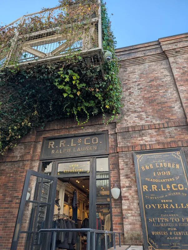 Entrance to the R.R.L. & Co. Ralph Lauren store with an open door and ivy covering the brick facade in Harajuku, Tokyo, Japan