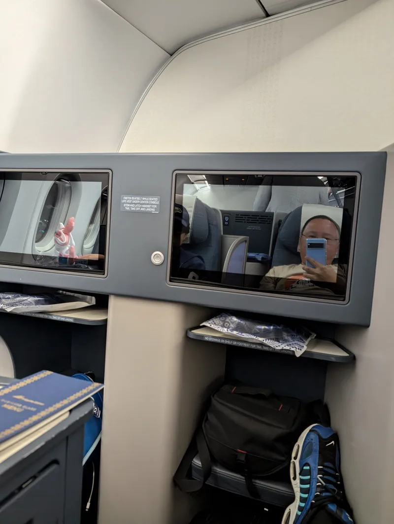 First row, business class — Philippine Airlines, Haneda to Manila Airplane business class seat with two entertainment screens aboard a Philippine Airlines flight from Tokyo Haneda Airport, Japan.