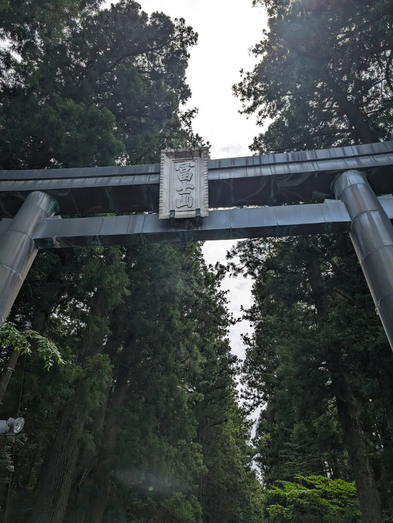 Torii gate framing a forested path at Fuji Sengen-Jinja Shrine, Fujiyoshida, Yamanashi, Japan.