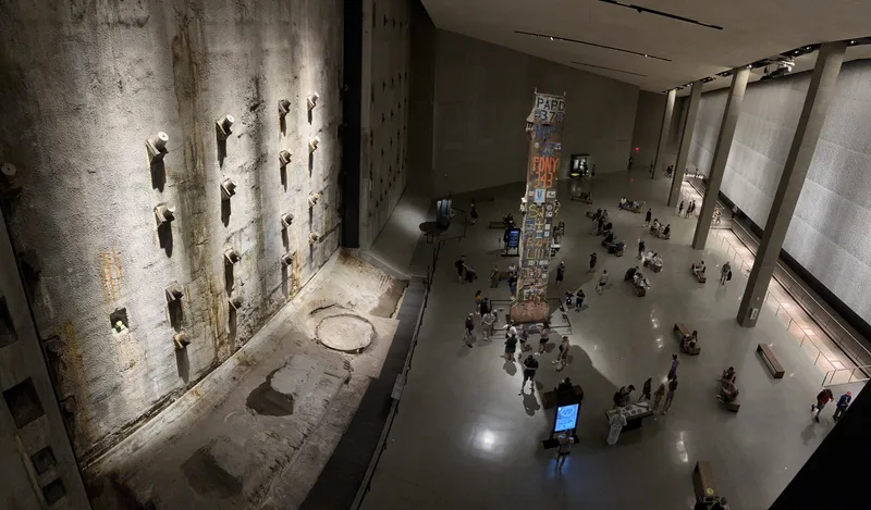 Overhead view of 9/11 Memorial Museum main hall with slurry wall and visitors
