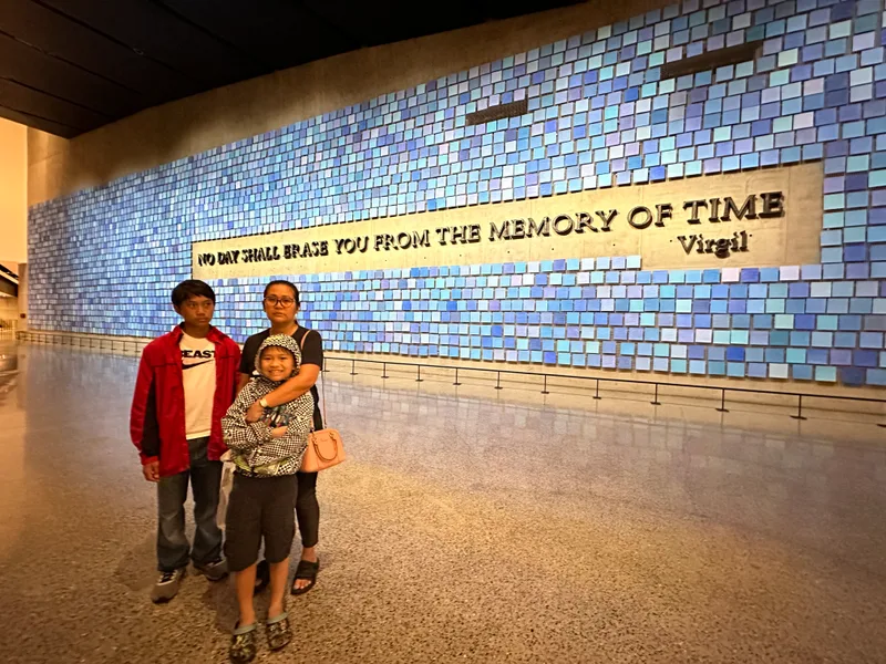 Family at 9/11 Museum, blue tiled memorial wall with Virgil quote