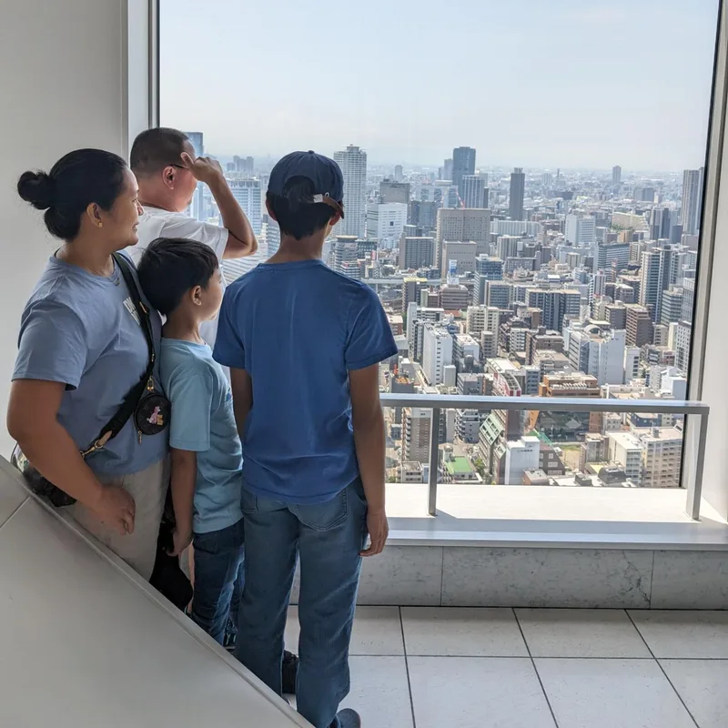 Family looking out over Osaka, Japan from the Umeda Sky Building observation deck.