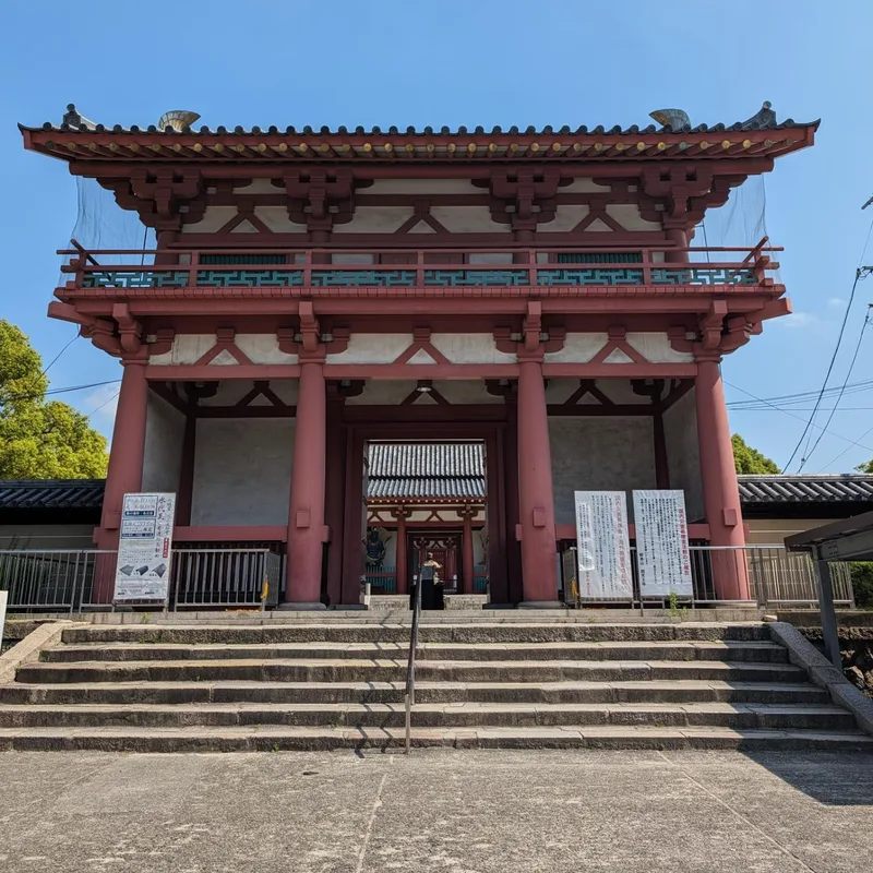 Grand red wooden gate with stone steps at Shitennoji Temple in Osaka, Japan.