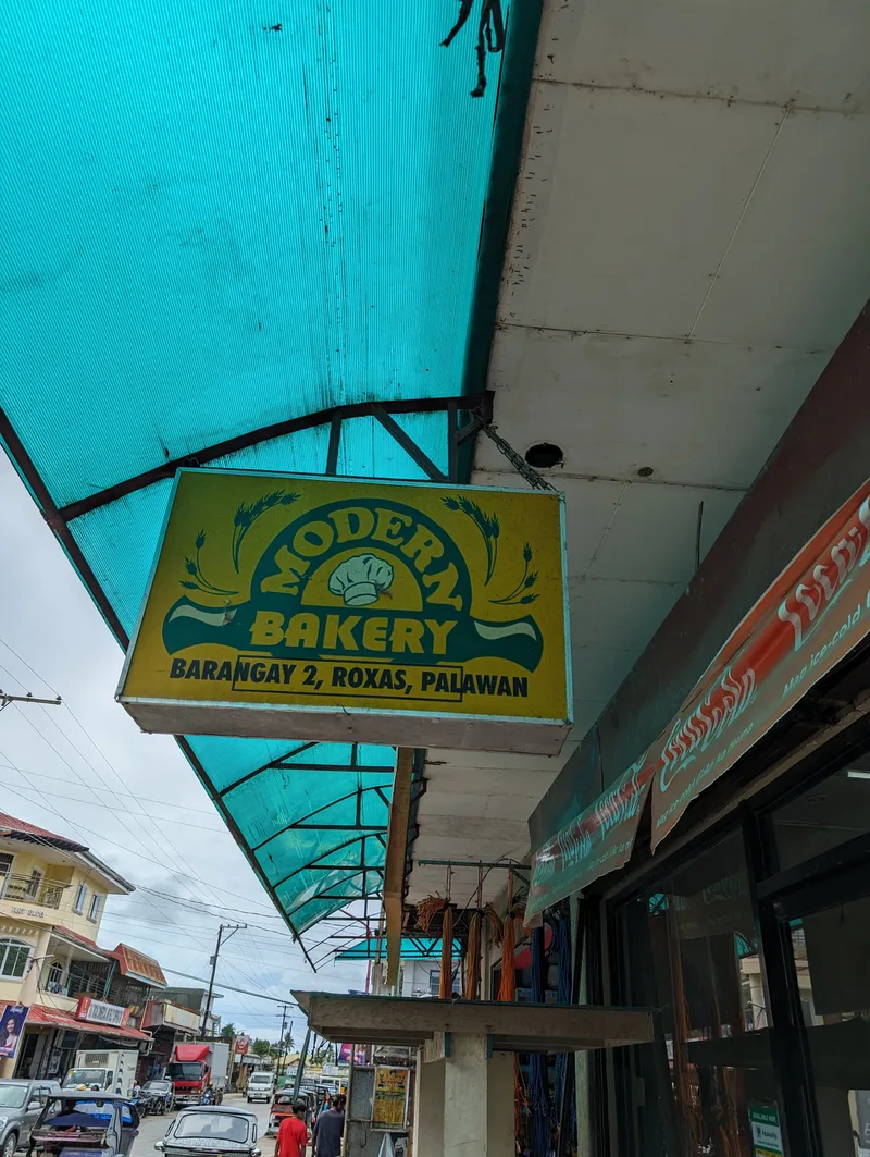 Modern Bakery yellow and blue sign under a blue corrugated awning in Barangay 2 Roxas Palawan Philippines