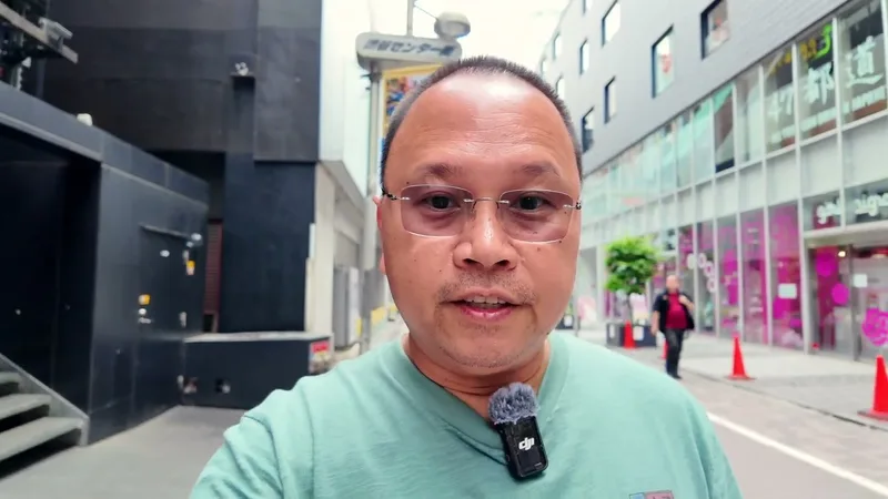 Shibuya streets at night, Tokyo, Japan Man taking a selfie video on a street in Shibuya, Tokyo, Japan, at night, shops and an alleyway visible in the background.