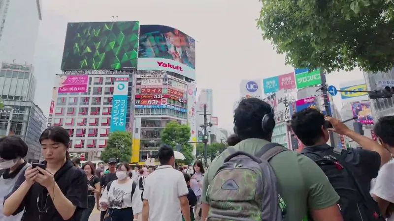 Shibuya Crossing on a Monday afternoon — Shibuya, Tokyo, Japan. Busy, but nothing like the weekend Pedestrians crossing at the famous Shibuya Crossing in Shibuya, Tokyo, Japan, with large digital billboards and tall buildings visible under an overcast sky.