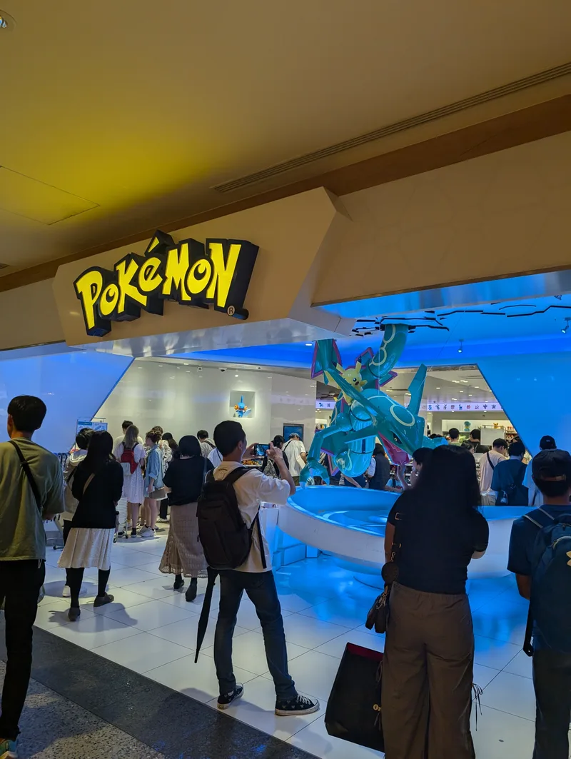 Pokémon Center at Solamachi — Tokyo Skytree complex, Tokyo, Japan Entrance to the Pokémon Center at Solamachi in the Tokyo Skytree complex, with a large illuminated Pokémon logo and a prominent Rayquaza statue, crowds of visitors gathered outside, Tokyo, Japan.