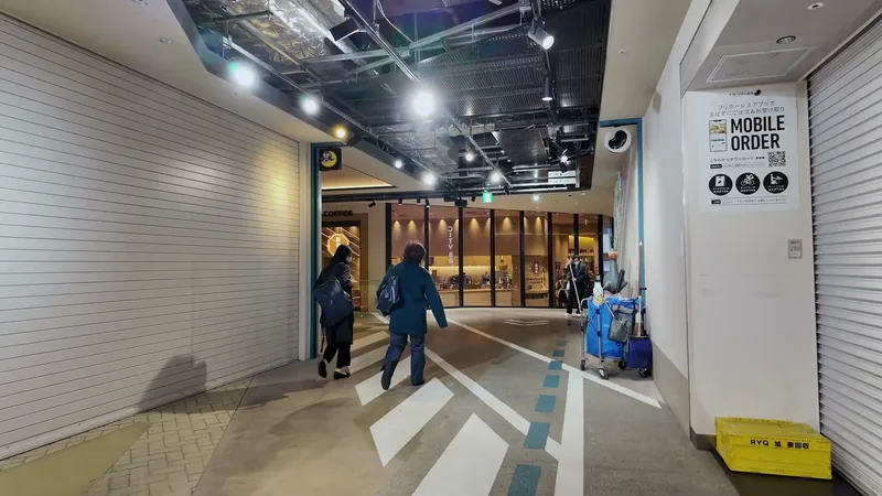 Walking through the ground floor corridor of Hotel Indigo with suitcases heading toward Don Quijote in Shibuya, Tokyo, Japan