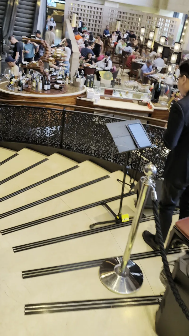 Grand staircase at the Spiral buffet at Sofitel Philippine Plaza, Manila, leading down to the restaurant floor with diners.
